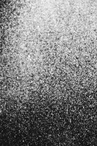 капли воды в воздухе на черном фоне размыты
