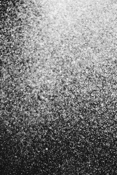 капли воды в воздухе на черном фоне размыты
