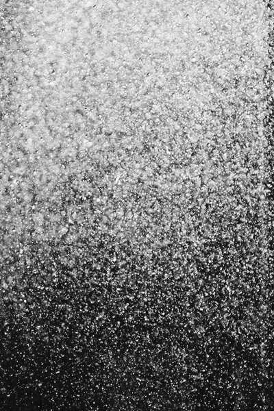 капли воды в воздухе на черном фоне размыты
