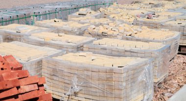 Bir palet üzerinde yığılmış tuğla kiremit