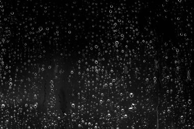 Siyah cam üzerinde yağmur damlaları