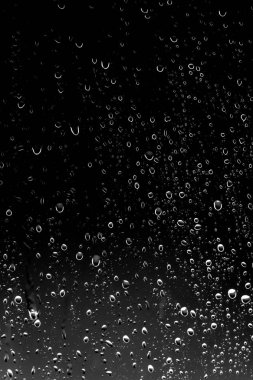 Siyah cam üzerinde yağmur damlaları