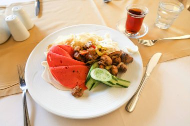 bir tabak içinde gıda: mantar, makarna ve sosis.