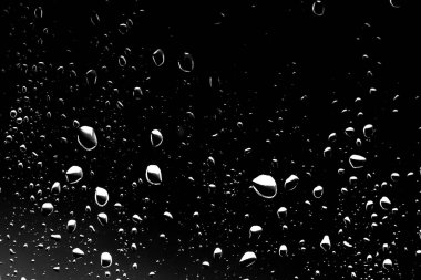 Siyah cam, ıslak cam doku üzerinde yağmur damlaları