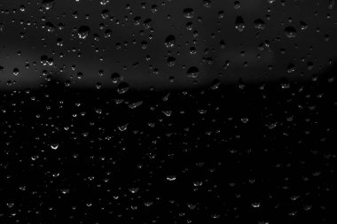 Siyah cam, ıslak cam doku üzerinde yağmur damlaları