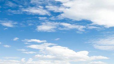 Beyaz bulutların üstünde mavi bir gökyüzü güneşli