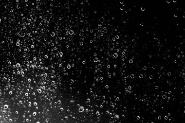 Siyah cam, ıslak cam doku üzerinde yağmur damlaları