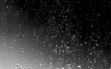 Siyah cam, ıslak cam doku üzerinde yağmur damlaları