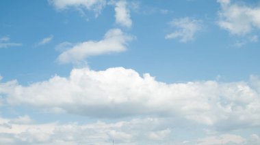 Beyaz bulutların üstünde mavi bir gökyüzü güneşli