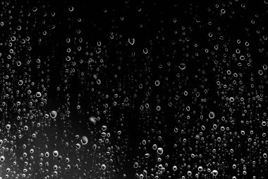Siyah cam, ıslak cam doku üzerinde yağmur damlaları