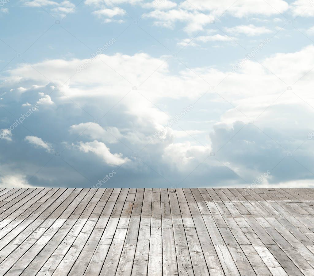 wooden floor against the sky with clouds