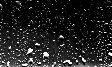 Siyah cam, ıslak cam doku üzerinde yağmur damlaları