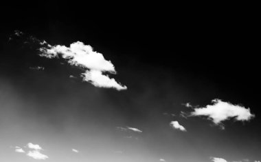 Beyaz bulutların üzerinde karanlık bir gökyüzü, tek renkli