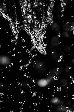 İçinde karanlık bir uçuş, ufuk bokeh su damlaları ile su sıçrama.