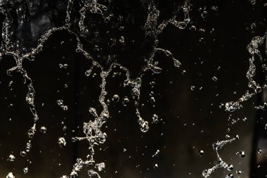 İçinde karanlık bir uçuş, ufuk bokeh su damlaları ile su sıçrama.