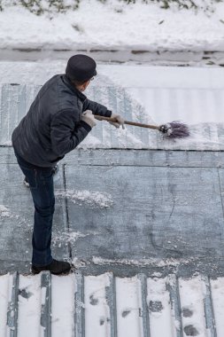 bir süpürge ile kar adam süpürür
