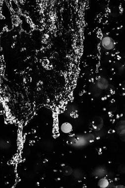 İçinde karanlık bir uçuş, ufuk bokeh su damlaları ile su sıçrama.