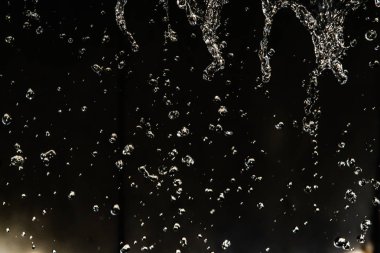 İçinde karanlık bir uçuş, ufuk bokeh su damlaları ile su sıçrama.