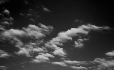 Beyaz bulutların üzerinde karanlık bir gökyüzü, tek renkli