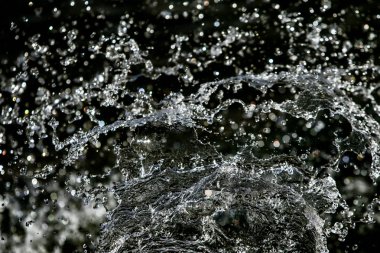 İçinde karanlık bir uçuş, ufuk bokeh su damlaları ile su sıçrama.