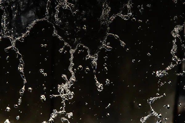 İçinde karanlık bir uçuş, ufuk bokeh su damlaları ile su sıçrama.