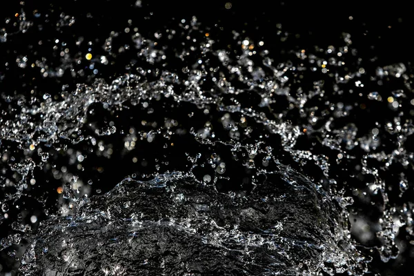 water drops in the air on a dark bokeh background