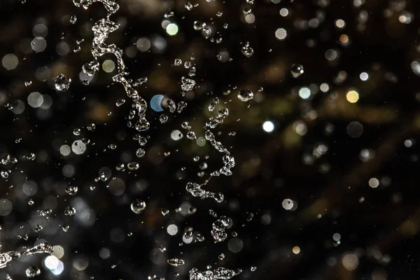 Salpicos Água Escuro Com Uma Gota Água Voando Bokeh Desfocado — Fotografia de Stock