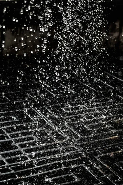 İçinde karanlık bir uçuş, ufuk bokeh su damlaları ile su sıçrama.