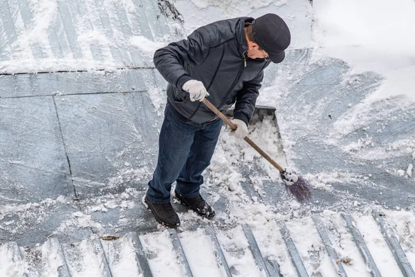 bir süpürge ile kar adam süpürür