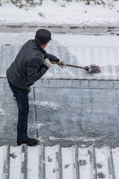 bir süpürge ile kar adam süpürür