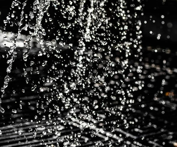 İçinde karanlık bir uçuş, ufuk bokeh su damlaları ile su sıçrama.