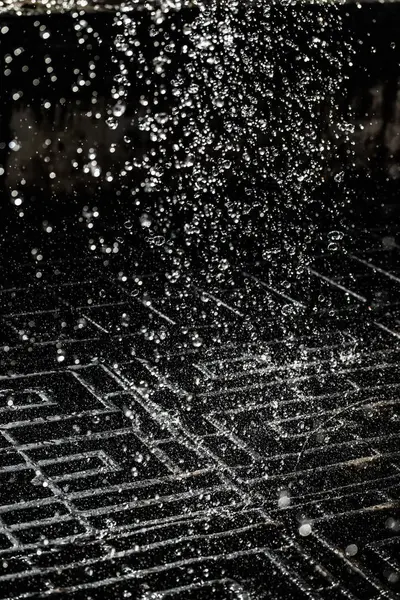 İçinde karanlık bir uçuş, ufuk bokeh su damlaları ile su sıçrama.