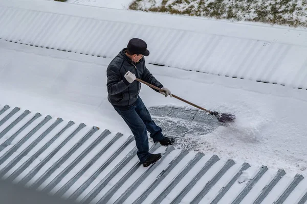bir süpürge ile kar adam süpürür