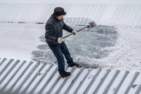 bir süpürge ile kar adam süpürür