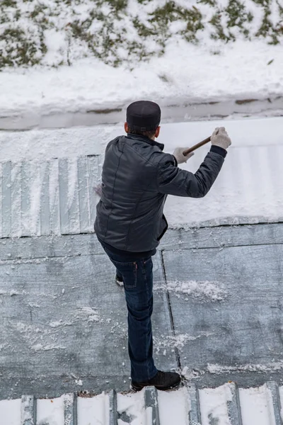 bir süpürge ile kar adam süpürür