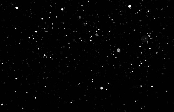 Snowstorm texture. Bokeh lights on black background, shot of flying snowflakes in the air