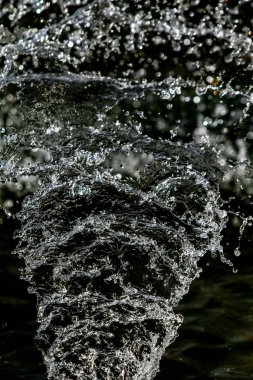 İçinde karanlık bir uçuş, ufuk bokeh su damlaları ile su sıçrama.