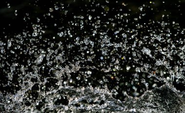 İçinde karanlık bir uçuş, ufuk bokeh su damlaları ile su sıçrama.