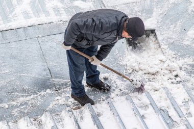 bir süpürge ile kar adam süpürür