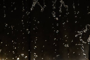 İçinde karanlık bir uçuş, ufuk bokeh su damlaları ile su sıçrama.