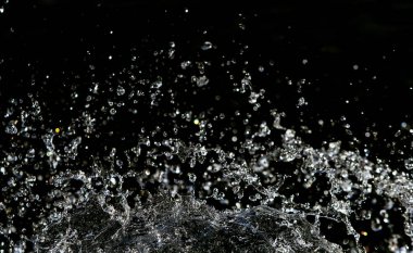 İçinde karanlık bir uçuş, ufuk bokeh su damlaları ile su sıçrama.