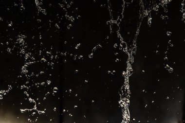 İçinde karanlık bir uçuş, ufuk bokeh su damlaları ile su sıçrama.