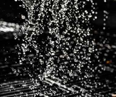 İçinde karanlık bir uçuş, ufuk bokeh su damlaları ile su sıçrama.