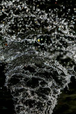 İçinde karanlık bir uçuş, ufuk bokeh su damlaları ile su sıçrama.