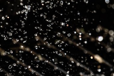 İçinde karanlık bir uçuş, ufuk bokeh su damlaları ile su sıçrama.