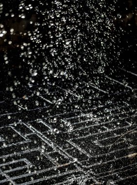 İçinde karanlık bir uçuş, ufuk bokeh su damlaları ile su sıçrama.