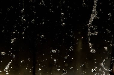 İçinde karanlık bir uçuş, ufuk bokeh su damlaları ile su sıçrama.