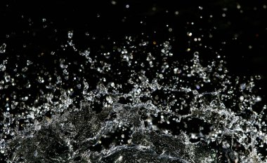 İçinde karanlık bir uçuş, ufuk bokeh su damlaları ile su sıçrama.