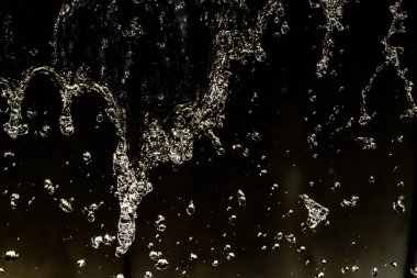 İçinde karanlık bir uçuş, ufuk bokeh su damlaları ile su sıçrama.