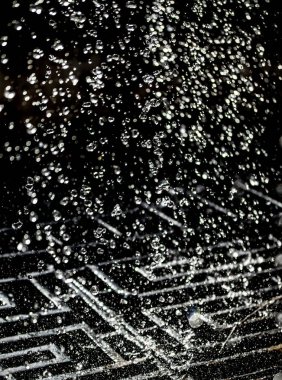 İçinde karanlık bir uçuş, ufuk bokeh su damlaları ile su sıçrama.